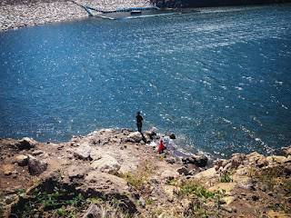 Two Men Fishing On Lake Water Of Largest Dam In Bali On A Sunny Day At Titab Ularan North Bali Indonesia