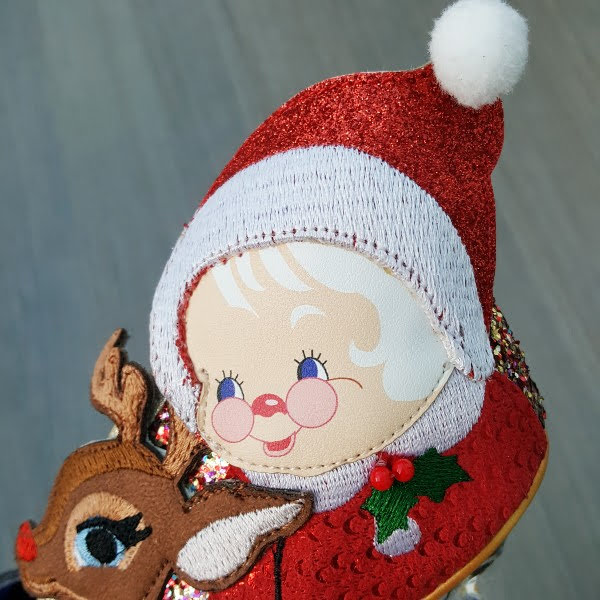 close up of Mrs Claus applique face on side of shoe with white pompom