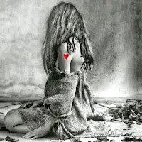 https://www.confesstoliz.com Black and white photo of a girl with long wavy hair sitting on the floor surrounded by flowers. The picture shows color only on the flowers and a heart tattoo on her shoulder
