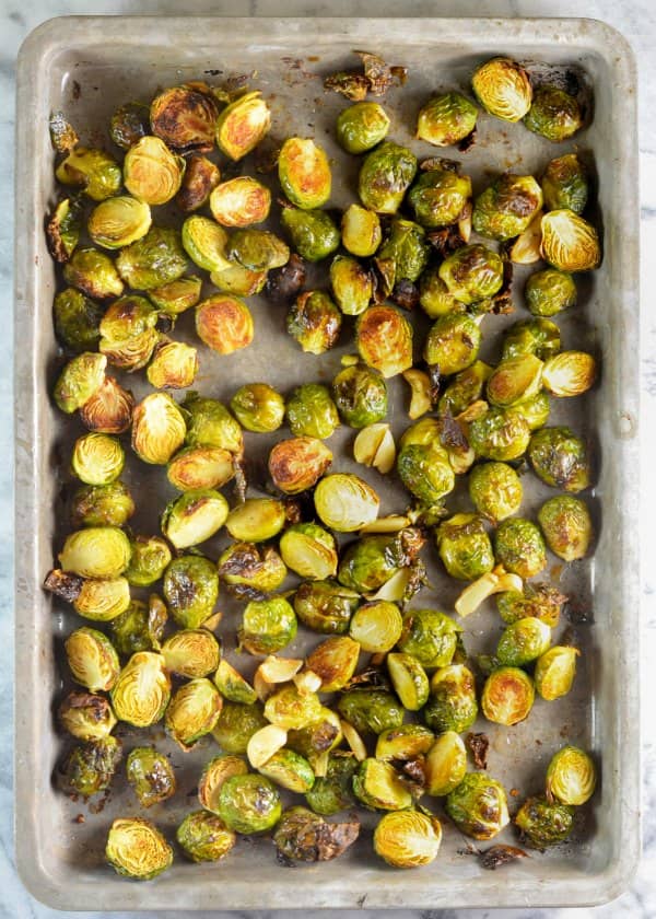 Roasted Brussels Sprouts with Garlic on a sheet pan drizzled with lemon juice and a great side dish recipe. A favorite for Thanksgiving and Christmas dinner from Serena Bakes Simply From Scratch.