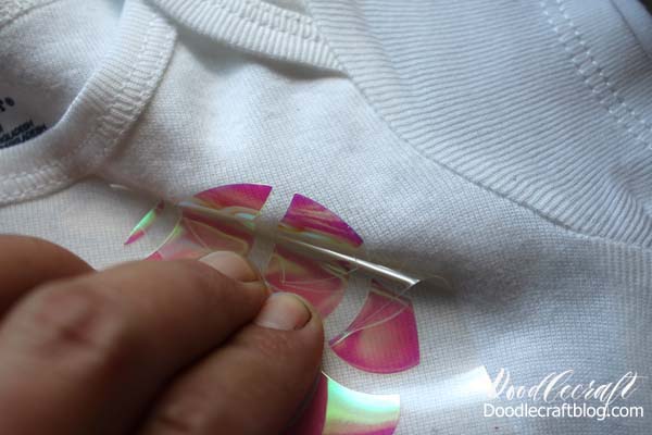 Peeling the carrier sheet off of the white baby onesie bodysuit from the pink Shimmering Holographic iron on vinyl from Cricut 