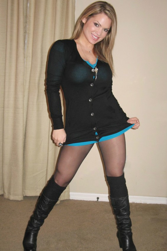 Beautiful woman wearing a blue dress with black tights and black boots