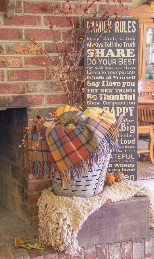 plaid blanket and fall flowers in a vintage olive basket