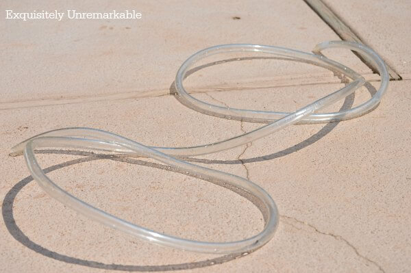 Plastic Tubing For Pond Fountain curled up on patio