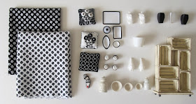 Selection of modern black and white dolls' house miniatures arranged on a desktop.