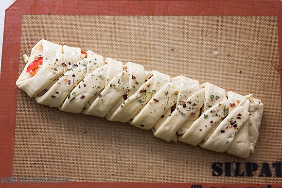 Stromboli trenzado con mortadela, queso y pimientos rojos. vía www.elgatogoloso.com