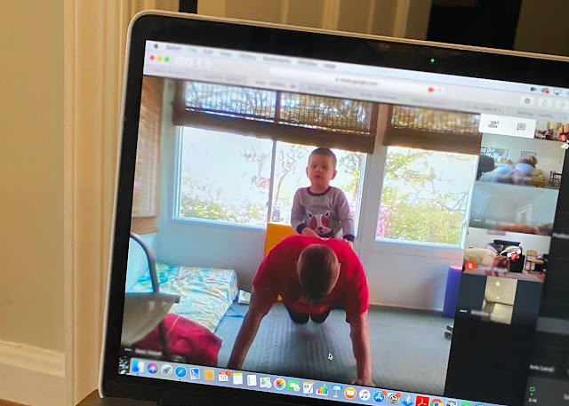 A laptop with a video conferencing page up showing various people working out on camera.