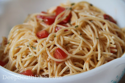 A cold spaghetti salad, made with angel hair, vermicelli or thin spaghetti, Italian dressing, fresh tomatoes and a variety of add-ins.