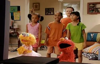 Zoe, Elmo and a few kids are watching Fuzzy and Blue And Healthy Too on TV. Sesame Street Happy Healthy Monsters