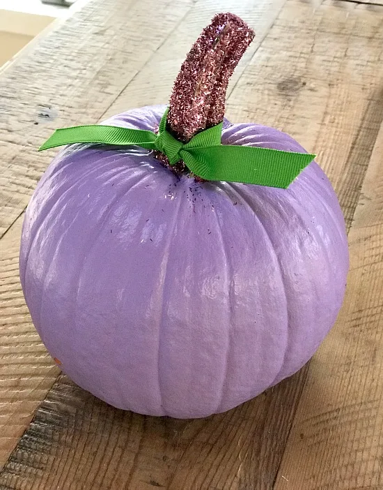 Purple painted pumpkin with green bow and glittered stem
