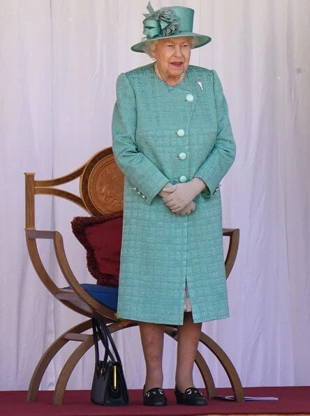 Queen is wearing a Stewart Parvin outfit, plus a floral silk dress with pleated hem detail, in shades of jade grey and dusty pink