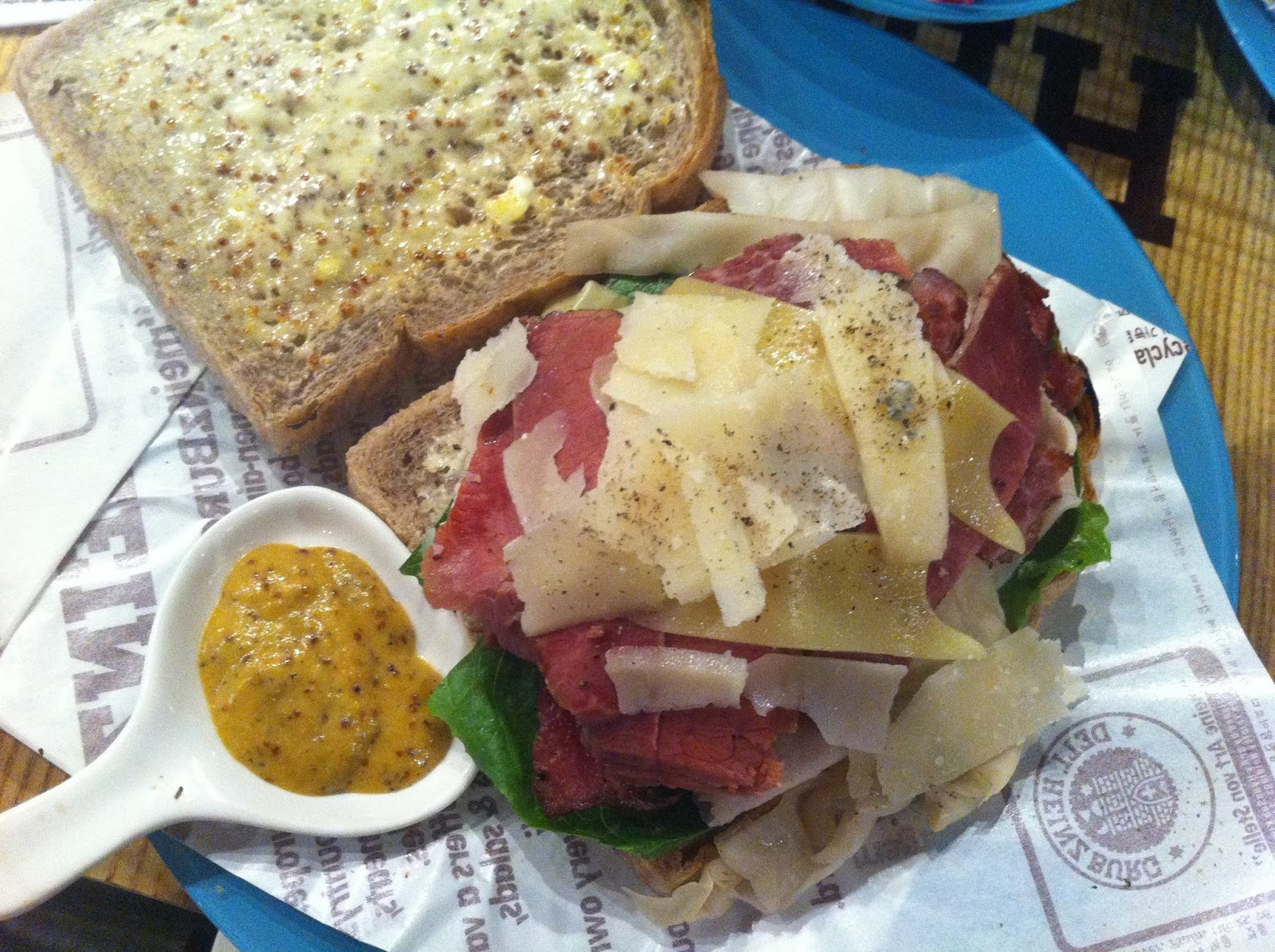 Colossal sandwich with multiple meats and cheeses.