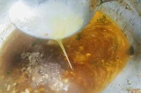 Pouring beaten egg into for chicken hot and sour soup recipe