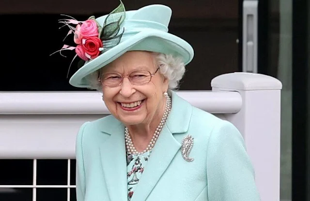 Queen Elizabeth wore an aquamarine coloured coat and dress and a matching hat adorned with pink flowers. Palm Leaf brooch