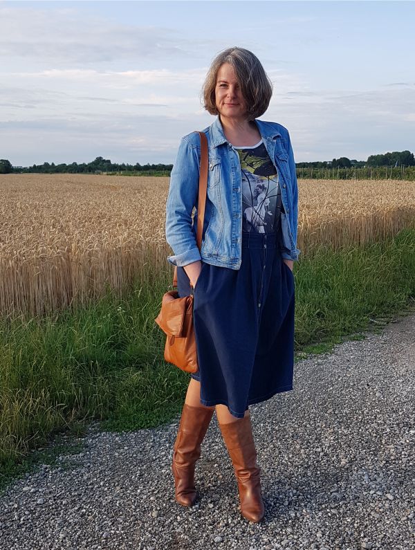 Kühler Sommerabend mit Midijeansrock in dunkelblauer Waschung, mit Knopfleiste, auf der Hüfte getragen und mit heller Jeansjacke kombiniert.