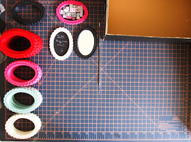 Stacks of various coloured rubber miniature baroque-style frames on a cutting mat