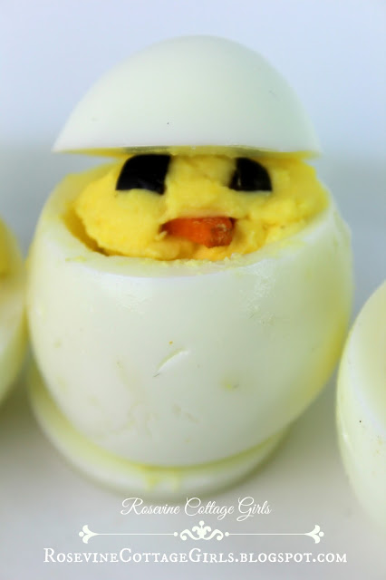 Deviled Easter Egg | Photo of a deviled egg made into a little chick with a face out of ripe olives and carrot triangles for a beak by Rosevinecottagegirls.com