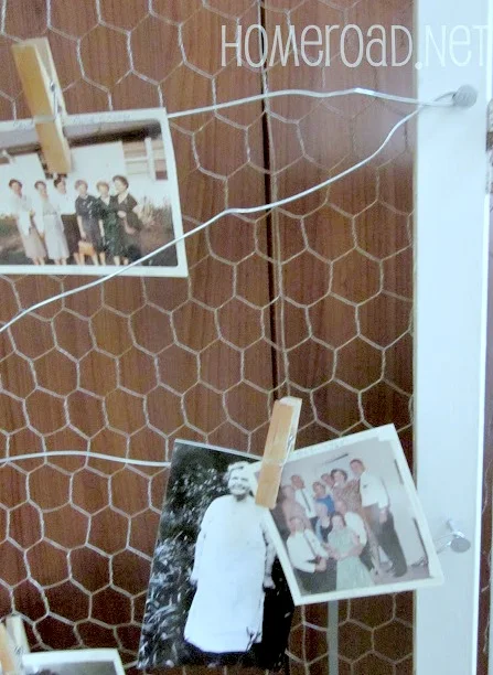 Chicken wire with photos hanging on wire.