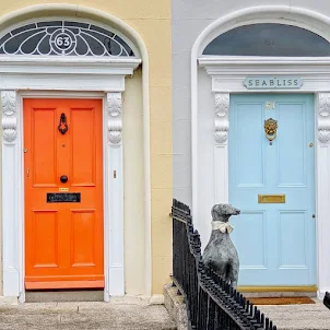 Orange and pale blue Dublin doors with dog statue on Sandymount Strand