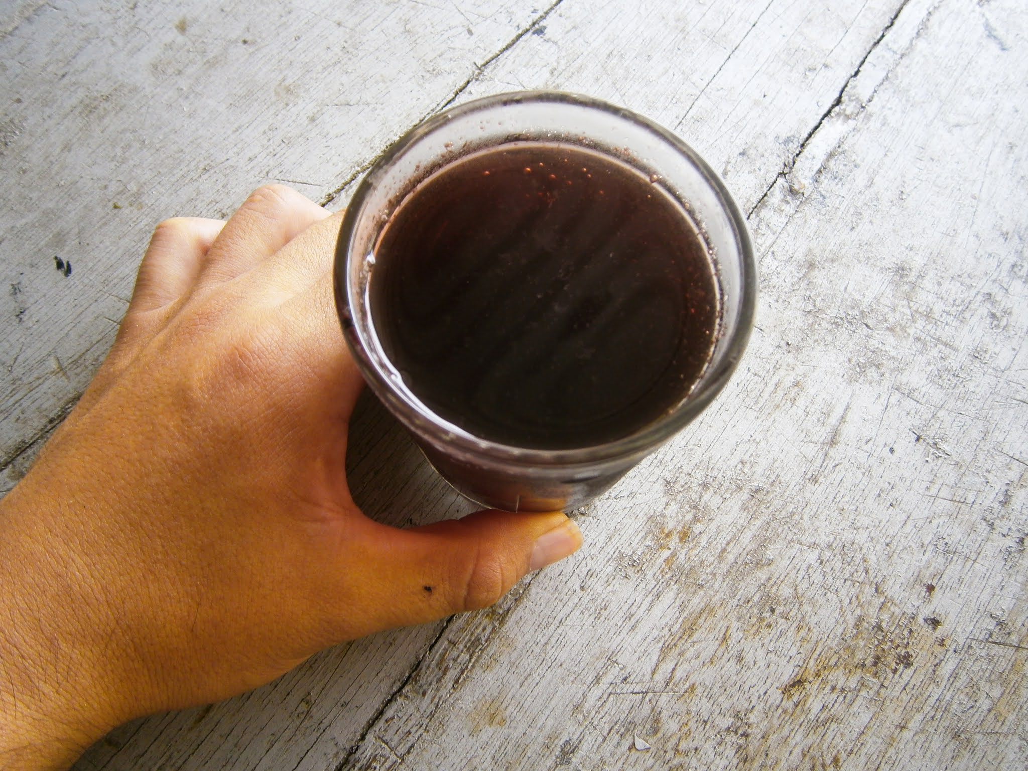 Vaso de chicha morada puesta sobre una mesa de color plomo