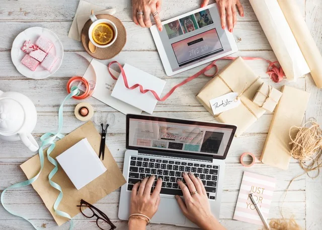 お茶を楽しみながらパソコンとタブレットを操作する2人の女性