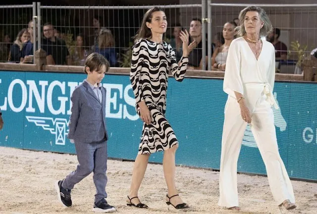 Princess Caroline wore a new wide short sleeve wrap front jumpsuit from Halston. Charlotte Casiraghi wore a new silk crepe dress from Chanel