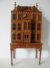 Dolls' house miniature wooden dolls' house mounted on a desk.