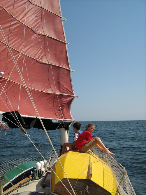Rheannon and Nicolas sitting on "Hatchling", the dinghy, enjoying the sail.