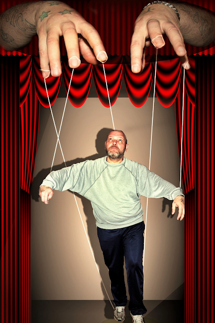 A man being manipulated and used as a puppet.