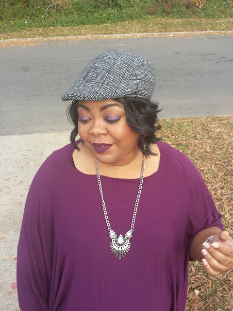 purple poncho with black jeans and fashion hat