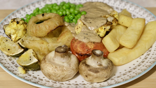 Home made peppercorn sauce over a cauliflower stake with onion rings, chips, tomato and garlic mushrooms