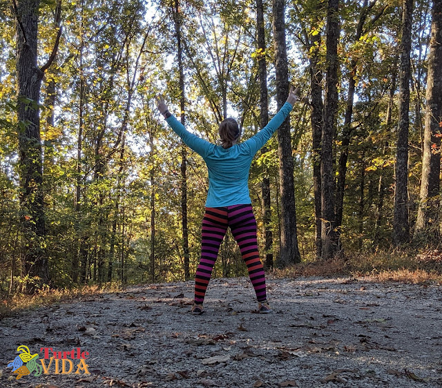 Woman with arms raised in a V taking in the beauty of the Mammoth Cave Railroad Hike & Bike Trail