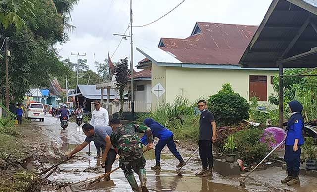 bersihkan sisa lumpur yang menutup jalan di Muaro Paneh