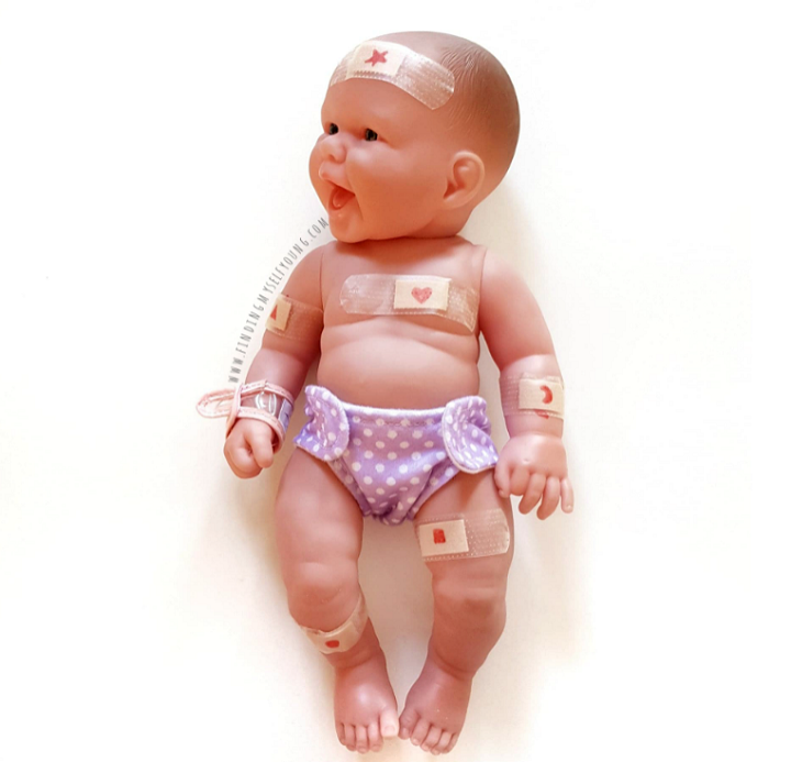 Shape bandaids stuck onto a plastic doll