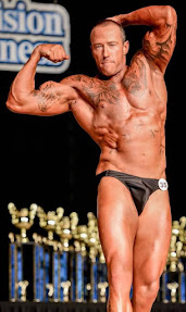 Dave Hoover when he was a body builder. Photo shows a white man wearing black briefs, flexing his muscles at a body-building competition