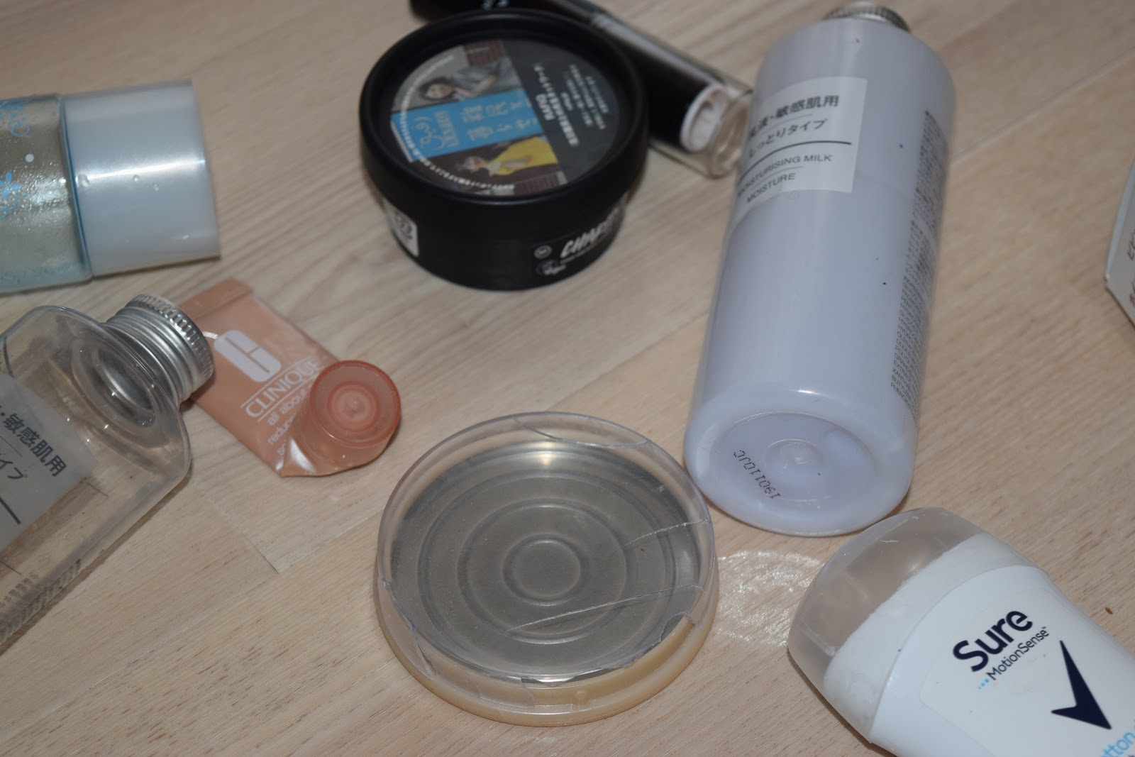 flatlay of empty products including Muji, Rimmel, Clinique, Emoda and Lush