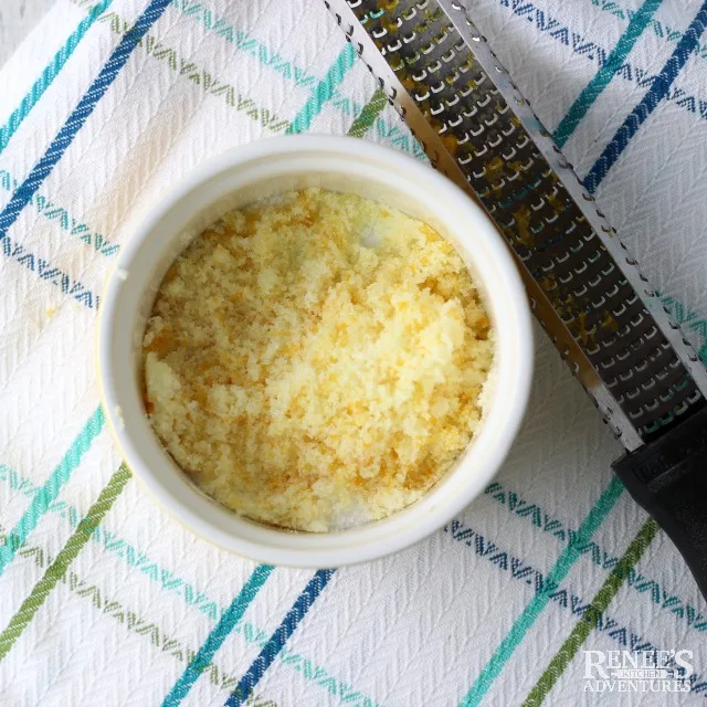 Sugar and orange zest mixed in a white bowl for Strawberries Romanoff | Renee's Kitchen Adventures