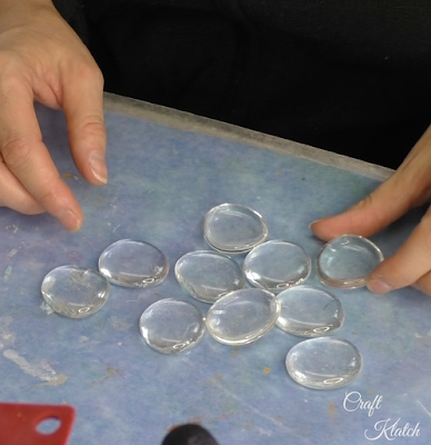 Ten glass gems laid out on a table.