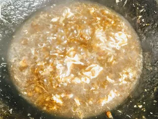 Pouring beat egg into soup for chicken manchow soup recipe