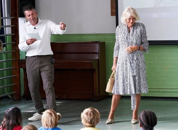 The Duchess of Cornwall is patron of The National Literacy Trust. The duchess wore a printed silk summer midi dress. beige pumps and bag