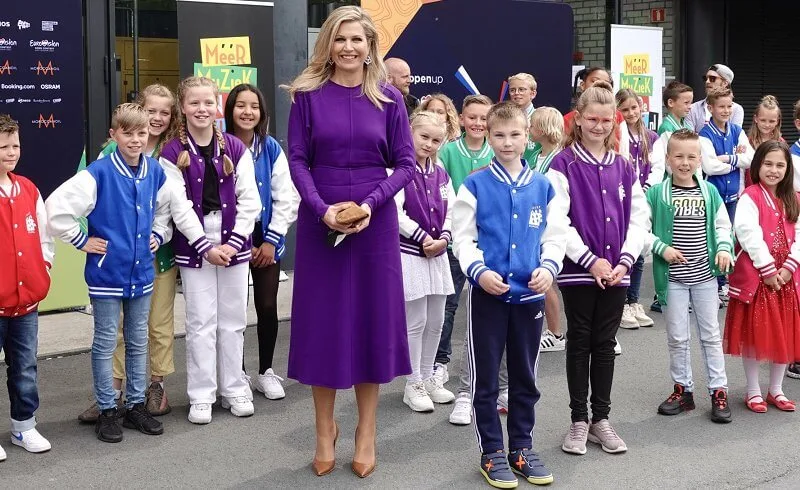 Queen Maxima wore a puffled sleeves dolman midi dress from Victoria Beckham, and yellow floral print silk satin dress from Natan