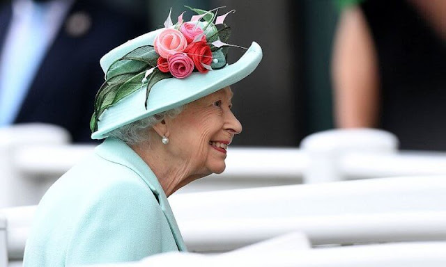 Queen Elizabeth wore an aquamarine coloured coat and dress and a matching hat adorned with pink flowers. Palm Leaf brooch