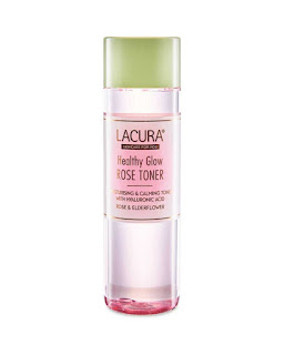 A cylindrical clear bottle filled with light pink liquid with a white circular lid and a white rectangular label with lacuna healthy glow rose toner in rose gold font on a bright background