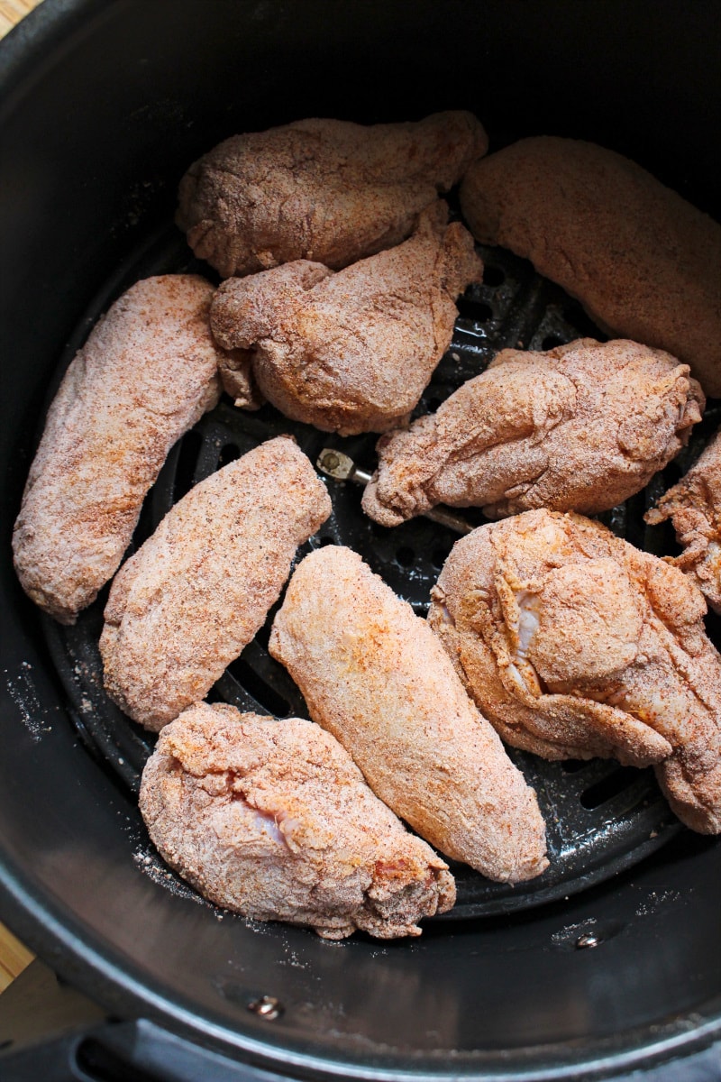 Top view of uncooked Air Fryer Breaded Chicken Wings in an air fryer basket.