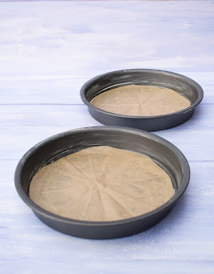 Two shallow, lined cake tins