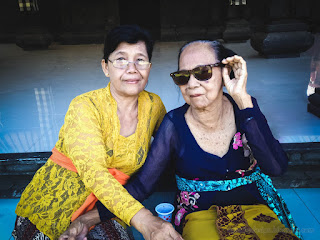 Two Grandmothers With Balinese Costume Are Sitting On The Resting Place In The Hindu Temple Area
