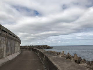 Lower walkway around grounds of Torness Nuclear Power Station.  Picture shows the concrete walkway and walls with a cloudy sky in the background.  Photo by Kevin Nosferatu for the Skulferatu Project