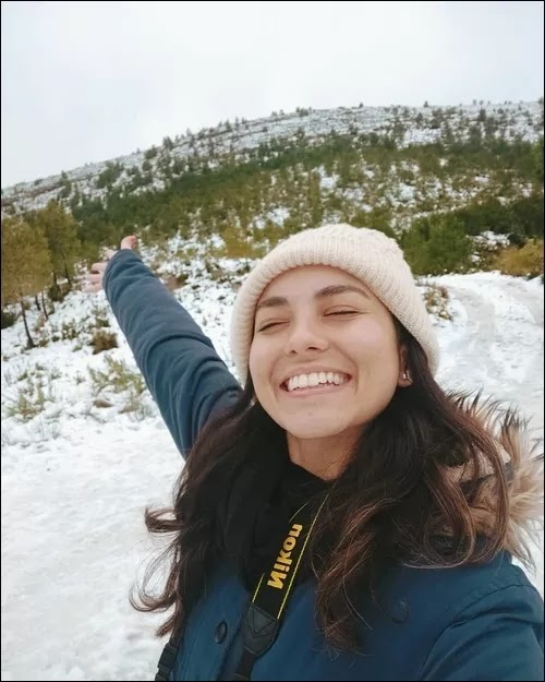 Chica en colina con nieve. Mariana, feliz.