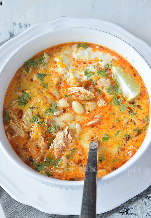 a white plate and white bowl with creamy white bean chicken chili