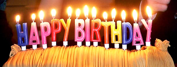 candles on top of a cake spell "HAPPY BIRTHDAY" in capital letters